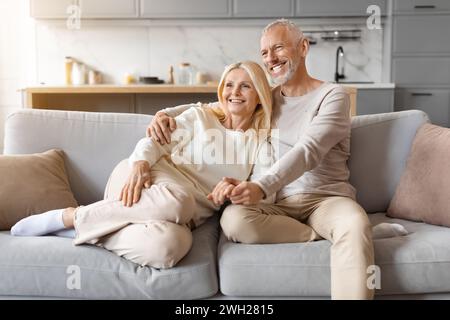 Schönes älteres weißes Paar kuschelt zu Hause auf der Couch Stockfoto