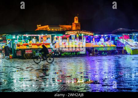 Marrakesch, Marokko - 04. April 2023: Regnerische Nachtszene auf dem Platz Jemaa el-Fnaa mit verschiedenen Verkaufsständen, Einheimischen und Besuchern in Marrakesch, Marokko Stockfoto