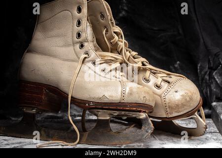 Alte Skates schäbig und abgenutzt auf einem verschneiten Hintergrund. Stockfoto