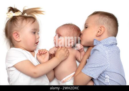 Closeup Portrait von drei fröhlichen Kinder liegend zu Hause, neugeborenes Baby mit Bruder und Schwester, glückliche Familie, Liebe und Freundschaft-Konzept Stockfoto