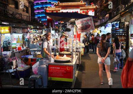 TAIPEI, TAIWAN - 4. DEZEMBER 2018: Händler kocht Street Food auf dem Raohe Night Market in Taipei. Nachtmärkte sind ein wichtiger Teil der taiwanesischen Kultur. Stockfoto