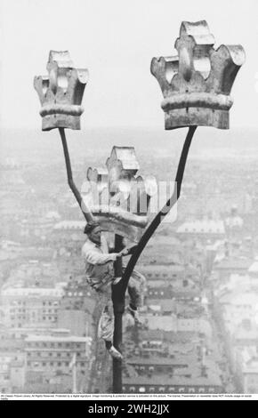 Stockholm in den 1940er Jahren Die Arbeiter warten auf dem Dach des Stockholmer Rathauses. Oben sind die schwedischen drei Kronen zu sehen, zusammen mit einem Arbeiter, der den ganzen Weg hinaufgestiegen ist. Schweden 1949 Stockfoto