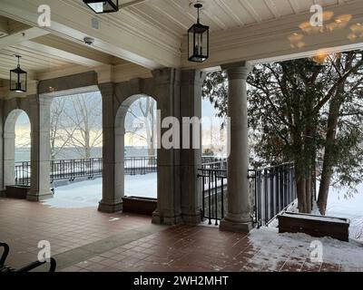 Ein Blick vom Innern des Hauses mit Blick auf eine Terrasse mit bogenförmigen Türen und einem Überhang. Stockfoto