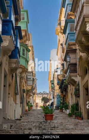 Valletta, Malta - 23. Dezember 2023: Treppen, die in die Altstadt von Valletta führen, mit Blick auf viele farbenfrohe Balkone der Gallarija Stockfoto