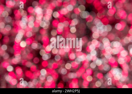 Verschwommenes Bokeh mit kleinen rosa und weißen Kreisen. Hintergrund. Stockfoto
