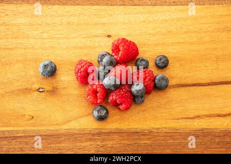 Raspberries and blueberries on a wooden snack board. Stockfoto