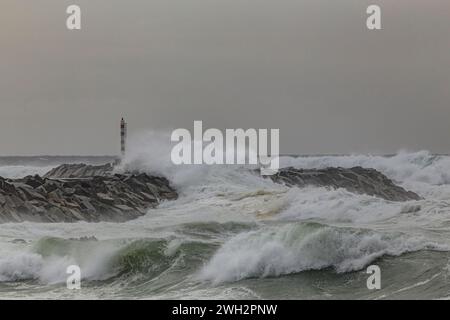 Wellenbrecher und Leuchtfeuer im Sturm vom kleinen Hafen von Angeiras, nördlich von Portugal. Stockfoto