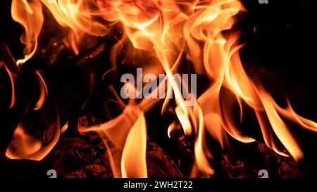 Kochen auf einem Kessel am Feuer. Flammen aus Feuer im Dunkeln. Stockfoto
