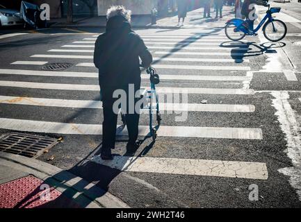 Eine ältere Frau mit ihrem Walker betritt am Samstag, den 3. Februar 2024, eine Kreuzung im Stadtteil Chelsea in New York. (© Richard B. Levine) Stockfoto