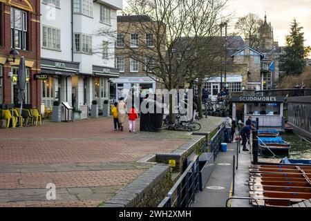 Menschen am Ufer des Flusses Cam neben Scudamore's Punting in Cambridge, Großbritannien Stockfoto