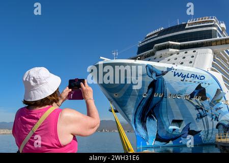 Manzanillo, Mexiko - 16. Januar 2024: Kreuzfahrtpassagier machen ein Foto des norwegischen Bliss-Ozeanschiffes auf einem Mobiltelefon Stockfoto