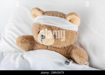 Der kranke Teddybär ist in Verbände gewickelt Stockfoto