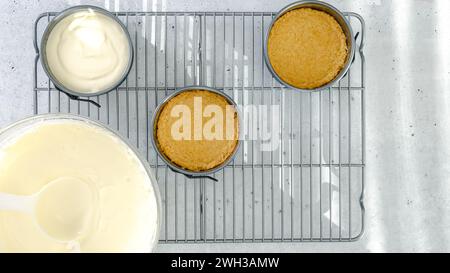 Kleines Käsekuchen-Rezept. Käsekuchen-Teig in eine vorbereitete Backform gießen, Nahzubereitung, flach legen Stockfoto