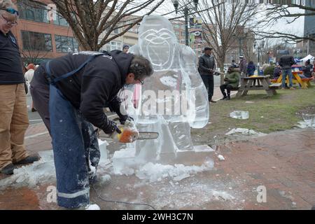 Jimmy Chiappa, Eisbildhauer, schneidet mit einer Kettensäge einen Gorilla aus Eisblöcken. Beim Fire Ice Festival im Columbus Park in Stamford, Connecticut Stockfoto