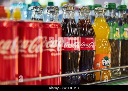 Regal im Geschäft mit Limonade verschiedener Marken. Coca Cola, Fanta, 7 Uhr. Aluminiumdosen und Glasflaschen in verschiedenen Größen. Getränke-Editorial, populär ca. Stockfoto