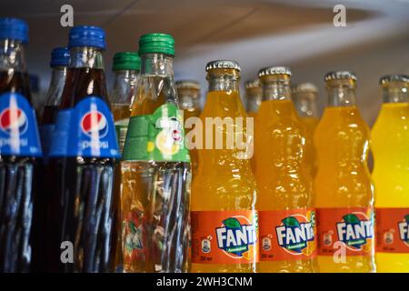 Pepsi, 7 auf, Fanta. Glasalkoholflaschen der Wettbewerber auf einem Kühlregal im Supermarkt. Getränk, beliebte kohlensäurehaltige Erfrischungsgetränke selec Stockfoto