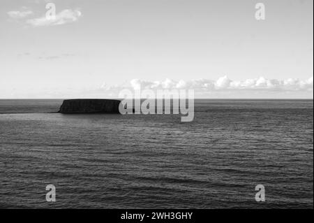 Eine kleine Insel im Meer in Nordirland, Schwarzweißfoto Stockfoto