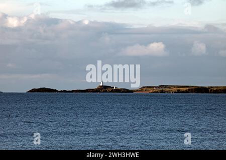 Blick über die Straße von Menai nach Traeth Llanddwyn und Goleudy Tŵr Mawr auf Ynys Llanddwyn, Llanddwyn Island, Anglesey, Nordwales. Stockfoto