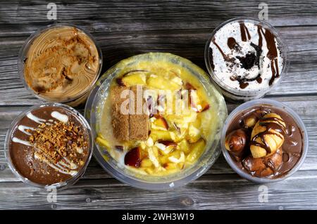 Hintergrund der verschiedenen Desserts von Schokolade Profiteroles, cremige Mousse mit Keksen, süße Mischung Dessert von Reispudding, Milchcreme Qishta, Basb Stockfoto