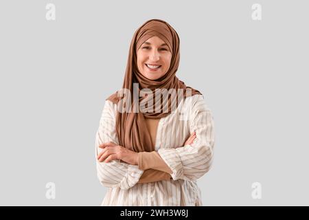 Reife muslimische Frau im Hijab auf hellem Hintergrund Stockfoto