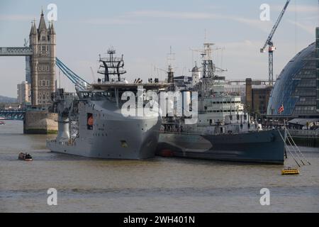 Die RFA Proteus, ein Schiff der Royal Fleet Auxiliary, liegt neben der HMS Belfast, einem Kreuzer aus dem Zweiten Weltkrieg. Die Themse, London, Großbritannien. 10. Oktober 2023 Stockfoto