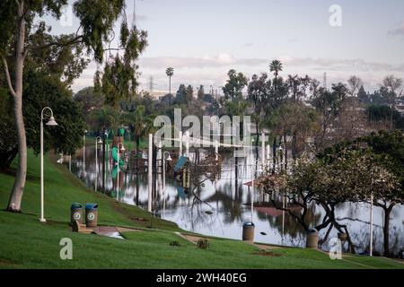 Unterer Spielplatz und großer Teich im Polliwog Park, überflutet vom Regen in Manhattan Beach, CA Stockfoto