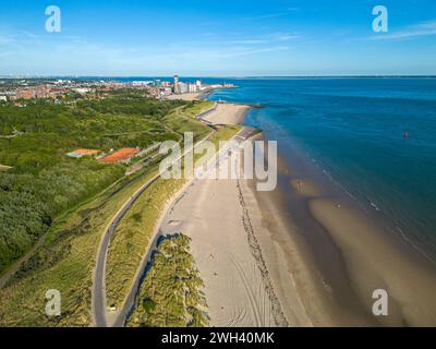 Luftaufnahme der Strandlinie und der Stadt Vlissingen, Niederlande im Hintergrund, vor blauem Himmel Stockfoto