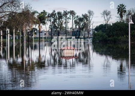 Unterer Spielplatz und großer Teich im Polliwog Park, überflutet vom Regen in Manhattan Beach, CA Stockfoto