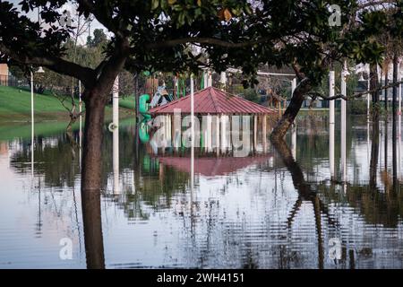 Unterer Spielplatz und großer Teich im Polliwog Park, überflutet vom Regen in Manhattan Beach, CA Stockfoto