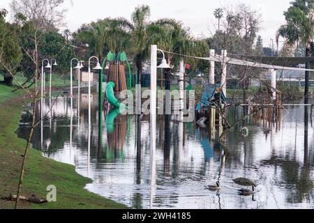 Unterer Spielplatz und großer Teich im Polliwog Park, überflutet vom Regen in Manhattan Beach, CA Stockfoto