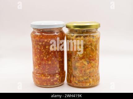 Gläser mit eingelegtem gehacktem Gemüse, für den Winter haltbar. Konzept für fermentiertes Gemüse. Pfeffer, Zwiebeln, Sellerie, Tomaten, Karotten. Stockfoto