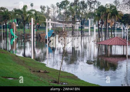 Unterer Spielplatz und großer Teich im Polliwog Park, überflutet vom Regen in Manhattan Beach, CA Stockfoto