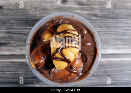 Schokoladen-Profiterole, mit Mini-Croissant gefüllt mit Schokolade, Soße, Erdnussbutter, Profiteroles sind Sahnepuffs, gefüllte französische Choux-Gebäck-Kugel Stockfoto