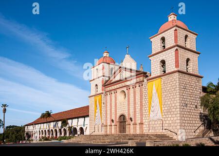 Santa Barbara, CA, USA - 20. April 2009: Alte Missionskirche und weiße Abteifassade mit rotem Dach unter blauer Wolkenlandschaft. Stockfoto