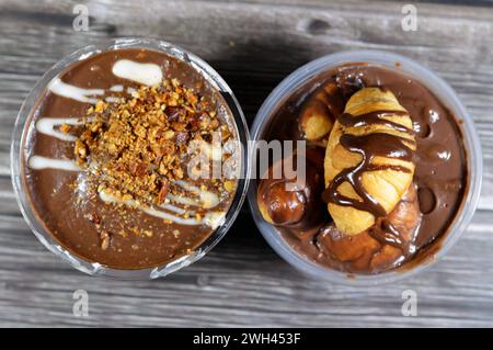 Cremige Schokoladen-Profiteroles, mit Mini-Croissants gefüllt mit Schokolade, Soße, Erdnussbutter, Mandeln, Profiteroles sind Creme-Puffs, gefüllt mit Französisch Stockfoto