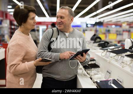 Seniorenpaar, das sich im Technikgeschäft für ein Tablet entschieden hat Stockfoto