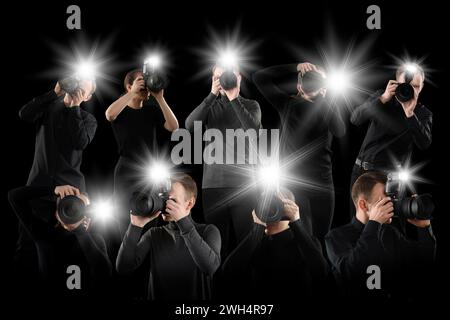 Gruppe von Fotografen mit Kameras auf schwarzem Hintergrund. Paparazzi machen Bilder mit Blitzen Stockfoto