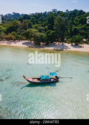 Langboot im türkisfarbenen Ozean mit klarem Wasser auf Koh Kradan, einer tropischen Insel in Trang Thailand, mit Blick auf die Drohne von oben Stockfoto