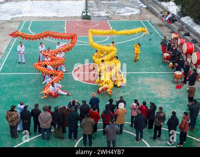 SUQIAN, CHINA - 7. FEBRUAR 2024 - zwei Drachen-Tanzteams feiern das Mondneujahr auf dem Zhongtong Village Square in Suqian, J Stockfoto