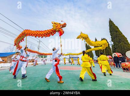 SUQIAN, CHINA - 7. FEBRUAR 2024 - zwei Drachen-Tanzteams feiern das Mondneujahr auf dem Zhongtong Village Square in Suqian, J Stockfoto