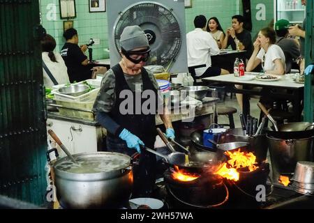 Bangkok, Thailand. Februar 2024. Die thailändische Supinya „Jay Fai“ Junsuta kocht am 7. Februar 2024 in ihrem Restaurant in Bangkok unverwechselbare Krabbenomelette. Supinya „Jay Fai“ Junsuta (80) hat sich den Prominenz-Status erworben, nachdem ihr Restaurant seit 2018 das einzige mit Michelin-Sternen ausgezeichnete Street Food-Restaurant in Thailand ist. das Restaurant wurde in den 1980er Jahren gegründet und ist bis heute in Betrieb und konzentriert sich hauptsächlich auf Wokkost. Es gibt Gerüchte, dass Supinya 'Jay Fai' Junsuta dieses Jahr ihre Geschäfte aufgeben wird. Quelle: SOPA Images Limited/Alamy Live News Stockfoto