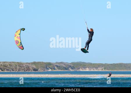 Ein luftgetragener Kitesurfer mit einem weiteren Kitesurfer im Hintergrund an der Mündung des Blackwood River, Augusta, Western Australia. Stockfoto