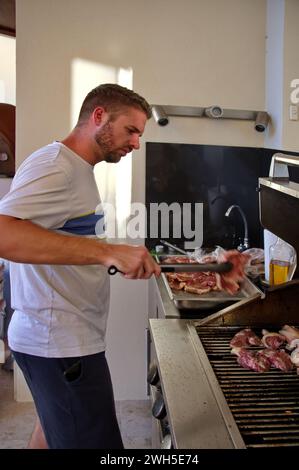 Junger, gutaussehender Mann, der im Hinterhof grillt Stockfoto