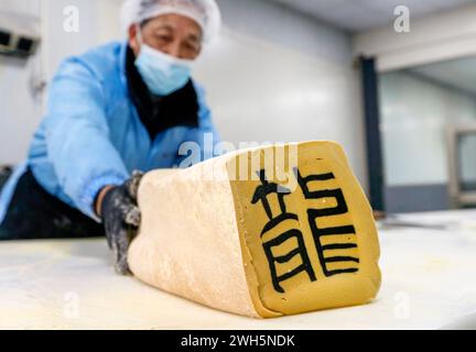 (240208) -- PEKING, 8. Februar 2024 (Xinhua) -- Jin Huimin, ein Erbe der Herstellung von Bonbons mit Charakter, stellt die Bonbons in Qimen County der Stadt Huangshan, ostchinesische Provinz Anhui, 31. Januar 2024 her. Im Vorfeld des Frühlingsfestes sind die Erben der Herstellung von Bonbons mit Charakter, einem immateriellen kulturellen Erbe im Qimen County, damit beschäftigt, die besonderen Süßigkeiten zu kreieren, die den Bedürfnissen der Menschen während des Festivals entsprechen. Die Herstellung der Süßigkeiten umfasst das Kochen von Zucker, das Mahlen von Pulver, das Rühren, das Verdichten, das Herstellen von eingelegten Zeichen, Stretching Sugar Bar und slic Stockfoto