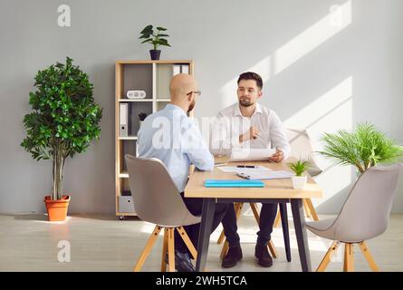 Zwei Geschäftsleute, die sich während der Besprechung im Büro unterhalten Stockfoto