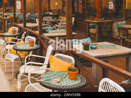 Ein Café im Freien mit rustikalen Holztischen und Bänken für komfortables Essen im Freien Stockfoto