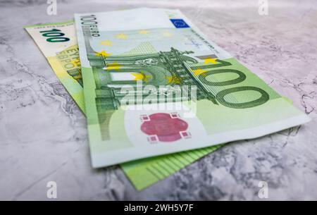 Nahaufnahme von 100 Euro-Banknoten, isoliert vor einem Hintergrund. Hochwertiges Nahaufnahme eines 100-Euro-Bandes auf Marmorhintergrund. Euro-Banknoten, Stockfoto