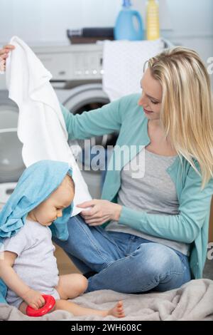 Mutter eine Hausfrau mit einem Baby, das in der Wäsche ist Stockfoto