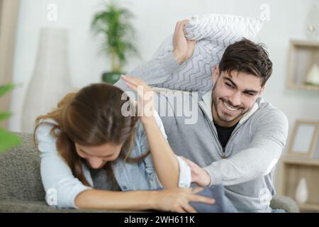 Ein junges Paar, das einen Polsterkampf hat Stockfoto