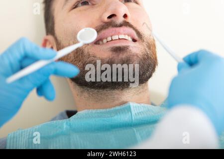Zahnärztin untersucht einen männlichen Patienten in der Klinik Stockfoto